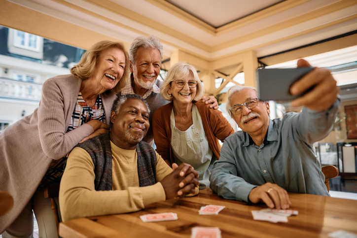 Cheerful senior having fun while taking selfie at retirement community.